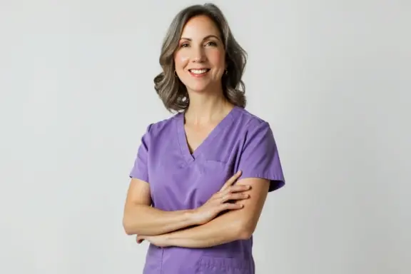 Dr. Jennifer Smith, dental coach and orthodontist, in purple scrubs smiling